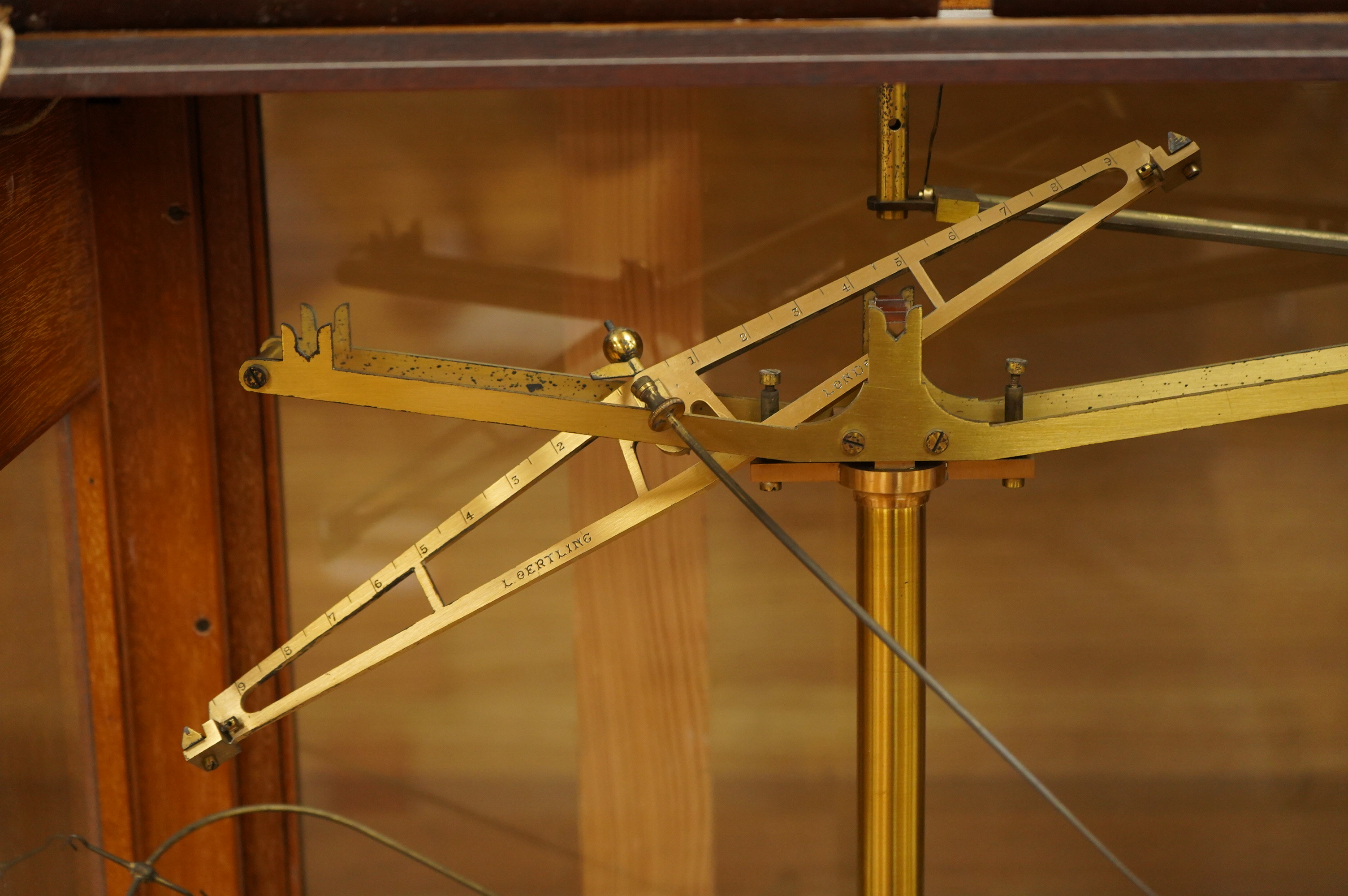 An early 20th century glazed mahogany cased laboratory chemical balance by Oertling, London, the drawer housing a set of weights, 45.5cm high, 50cm wide, 26cm deep